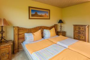 a bedroom with a large bed with orange sheets at Motel Steighof in Brütten