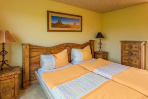 ein Schlafzimmer mit einem großen Bett mit orangefarbener Bettwäsche in der Unterkunft Motel Steighof in Brütten
