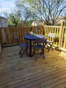 a table and chairs on a wooden deck at chalet 2 in Saint-Christol-lès-Alès