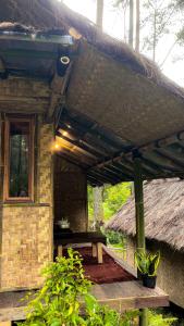 a pavilion with a picnic table and a thatch roof at ALAMSUKA Cikole in Tangkubanperahu
