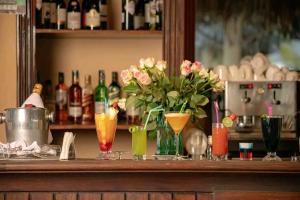 a bar with some drinks and flowers on a counter at Tembo Beach Cottage , Ocean Beach Drive in Malindi
