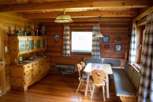 a dining room in a log cabin with a table and chairs at Almhütte Astental in Vordere Asten