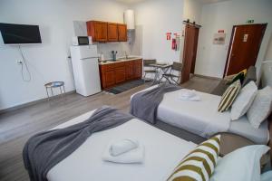 a room with two beds and a kitchen with a refrigerator at Mountain View Star in Estreito da Calheta
