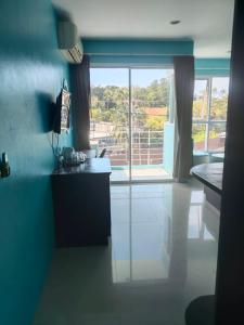 a kitchen with blue walls and a large window at Bedroom301 Kata Beach Phuket in Kata Beach +5 photos