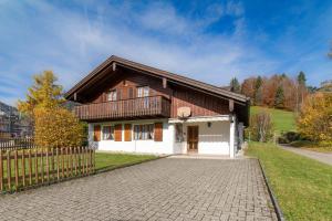 a house with a wooden roof and a brick driveway at Sonnegge in Wildhaus