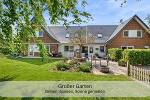 a house with a garden in front of it at Moderne Ferienwohnung in Strandnähe - Urlaubsträume am Meer in Neue Tiefe Fehmarn