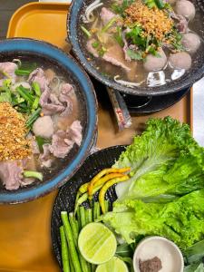 three bowls of soup and vegetables on a table at wooden tree nongkhai in Nong Khai