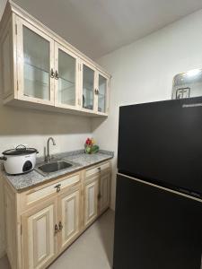 a kitchen with a black refrigerator and a sink at Ormoc Gdex Transient in Ormoc +13 photos