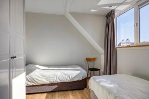 a bedroom with two beds and a window at Zonnehoek Terherne in Terherne