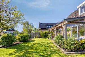 a garden with a pergola next to a house at Zonnehoek Terherne in Terherne