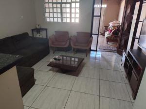 a living room with a couch and chairs and a table at Morada ind in Araguari