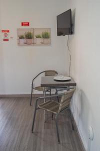 a room with a table and a chair and a tv at Mountain View Star in Estreito da Calheta