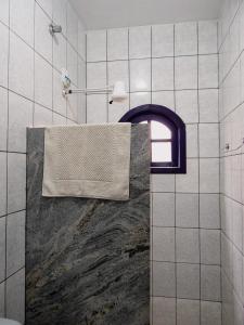 a bathroom with a shower with a towel on a window at Casa de Mariazinha in Ouro Preto
