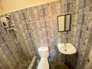a bathroom with a toilet and a sink at BICAMM Inn in Sampong