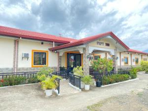 a building with potted plants in front of it at BICAMM Inn in Sampong +7 photos