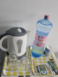 a tea kettle and a bottle of water on a tray at Perfect Ploiesti in Ploieşti