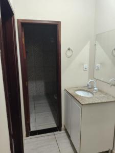 a bathroom with a shower with a sink and a mirror at Morada ind in Araguari