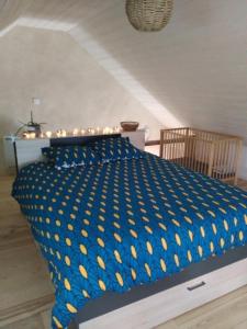 a bedroom with a bed with a blue and yellow comforter at Ti Forn - Les fours à pain in Dinéault