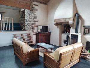 a living room with two chairs and a fireplace at Ti Forn - Les fours à pain in Dinéault