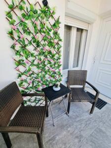 two chairs and a table with a wall of flowers at City house in Myrina