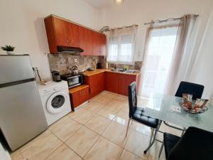 a kitchen with a table and a refrigerator and a washer at City house in Myrina