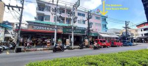 a busy city street with motorcycles driving past a building at Bedroom401 Kata Beach Phuket in Kata Beach