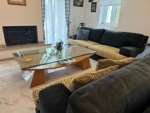 a living room with a couch and a glass table at Petrino in Levidi