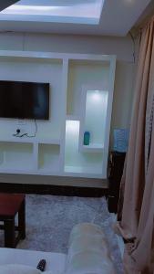 a living room with a flat screen tv on a wall at Amani Home in Kisii