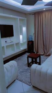 a living room with a couch and a flat screen tv at Amani Home in Kisii