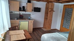 a small kitchen with a small table and a bed at Ferienhof Ziegler - Studio Fingerhut in Baiersbronn