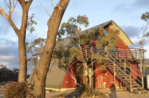 a red house with a staircase next to a tree at Blue Monkey Mountains in Newnes Junction