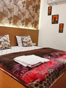a bed with blankets and pillows on top of it at Kaveri splendid apartment in Greater Noida
