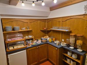 a kitchen with wooden walls and a counter with food at Pension Aberger - Joker Card inclusive in Saalbach-Hinterglemm +27 photos