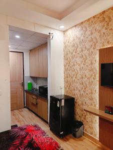 a kitchen with a black refrigerator in a room at Kaveri splendid apartment in Greater Noida
