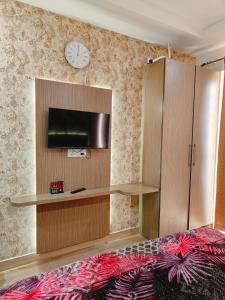 a bedroom with a bed and a tv and a cabinet at Kaveri splendid apartment in Greater Noida