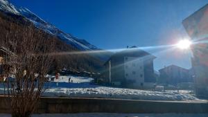 a sun is shining on a snow covered mountain at Sky Haus Residence inkl parking in Täsch