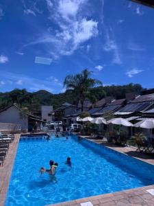 two people in the swimming pool at a resort at Pousada do Sol in Penedo