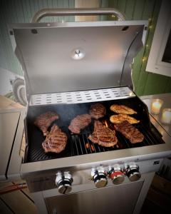a grill with hamburgers and hamburgers cooking at Maringotka Slaměnka u menhirového kruhu - U Slaměnky in Hněvětice