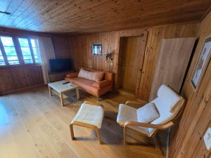 a living room with a couch and two chairs at Adli in Disentis