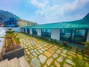 a building with a green roof and a yard at The Valley View Homestay in Lansdowne