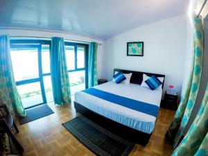 a bedroom with a bed and a large window at The Valley View Homestay in Lansdowne +7 photos
