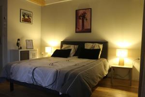 a bedroom with a large bed with two lamps at L'Autan sage in Montgeard