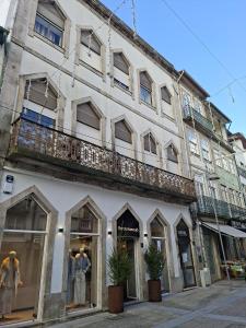 a large white building with windows and a balcony at Porta 80 House in Braga