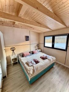 a bedroom with a large bed in a room with wooden ceilings at Domček pod Vežami s vírivkou a grilom, pri termálnom kúpalisku in Liptovský Ján
