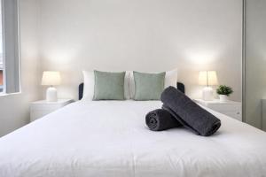 a bedroom with a white bed with towels on it at Epping Station Apartments in Epping