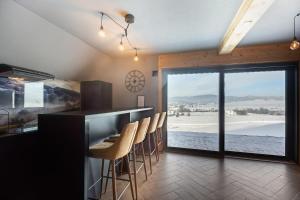 a kitchen with a bar with a view of the beach at Barn&Haus-Stodoły Widokowe in Zubrzyca Dolna