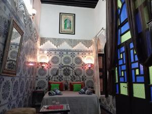 a bedroom with a bed with green pillows at DAR EL AAMOURI in Fez
