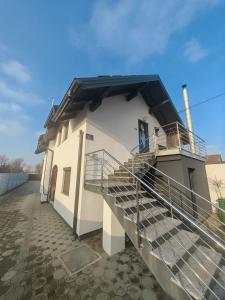 a white building with stairs and a balcony at Apartman Antonela in Sop