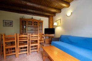 a living room with a blue couch and a table at La Borda del Pubill Resort in Ribera de Cardós