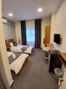 a hotel room with three beds and a television at Kahraman Amman Hotel in Amman +54 photos